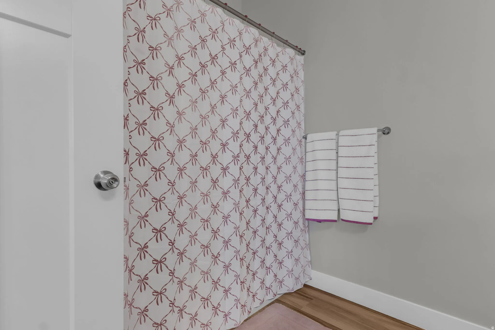 Bathroom with a shower with curtain and light wood finished floors