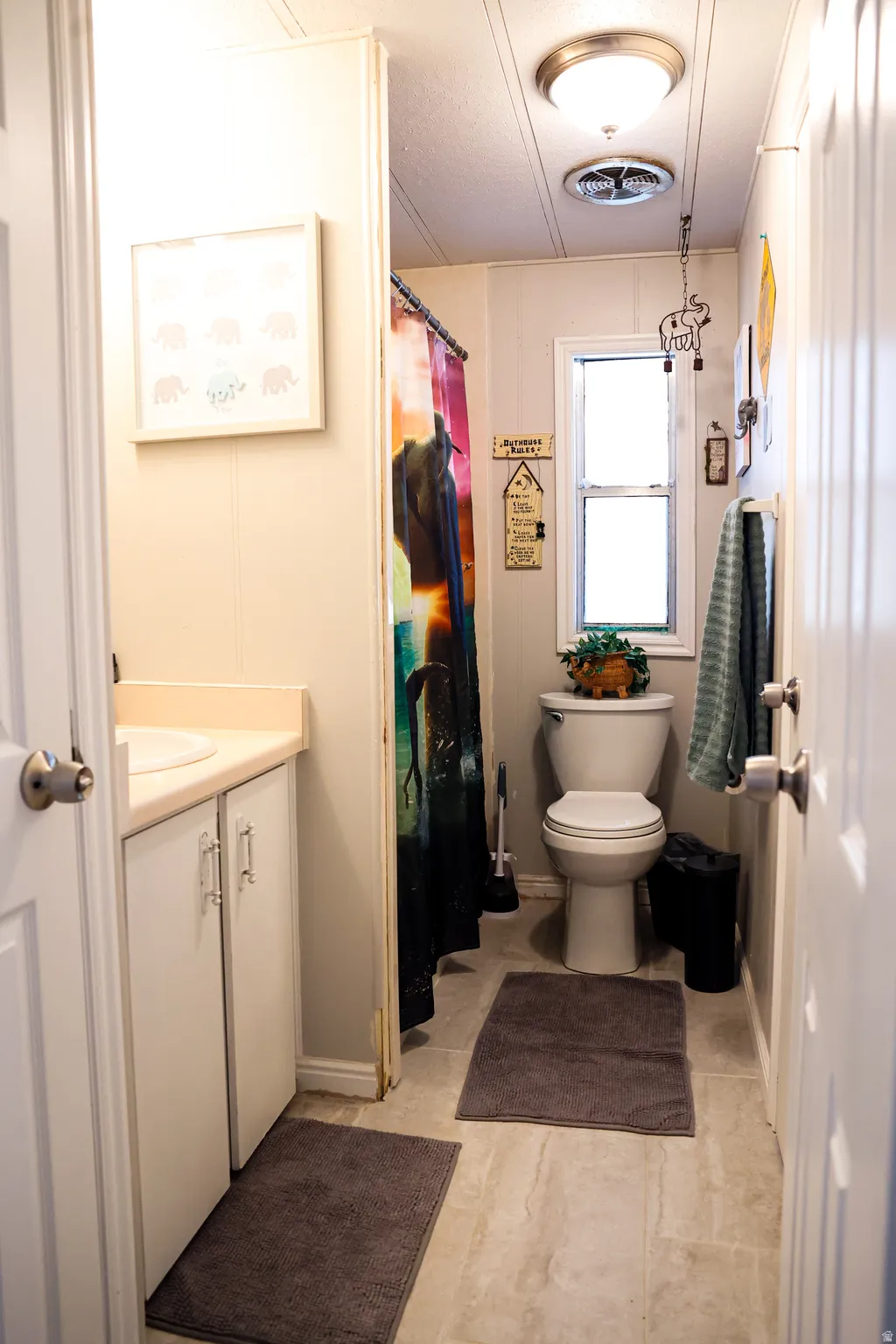 Full bathroom featuring vanity, curtained shower, and a decorative wall