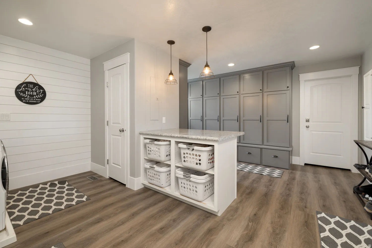 Kitchen featuring gray cabinetry, open shelves, dark wood finished floors, light stone counters, and hanging light fixtures