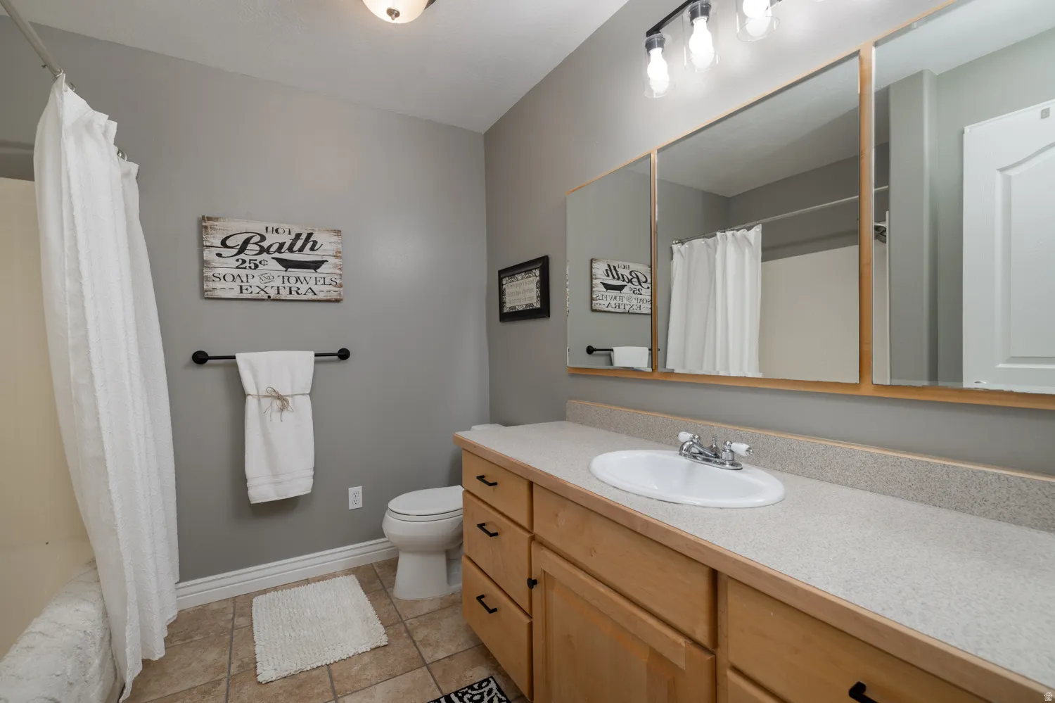 Bathroom with vanity, light tile patterned flooring, and shower / bath combination with curtain