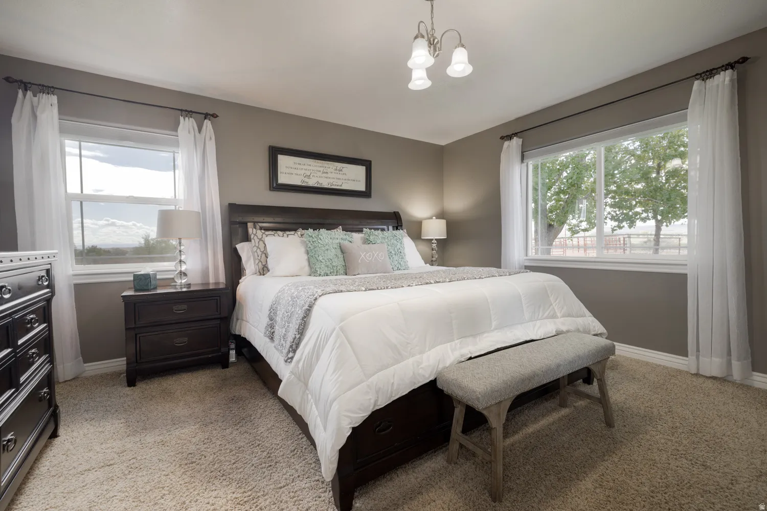 Bedroom featuring a chandelier and light carpet