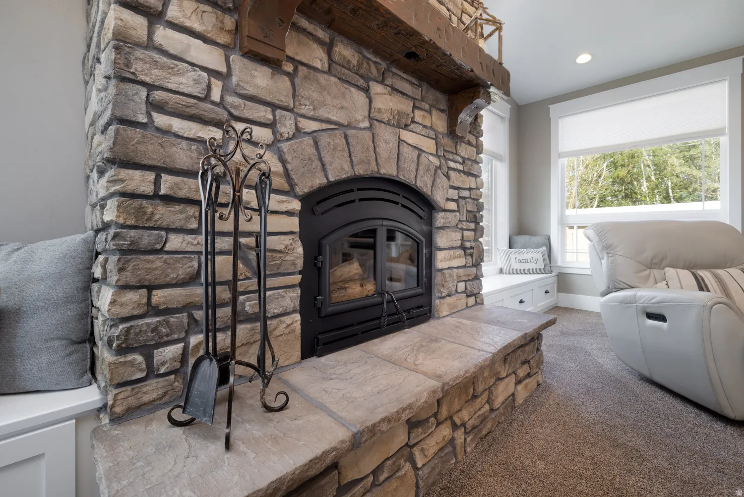 Living room featuring carpet floors and a stone fireplace