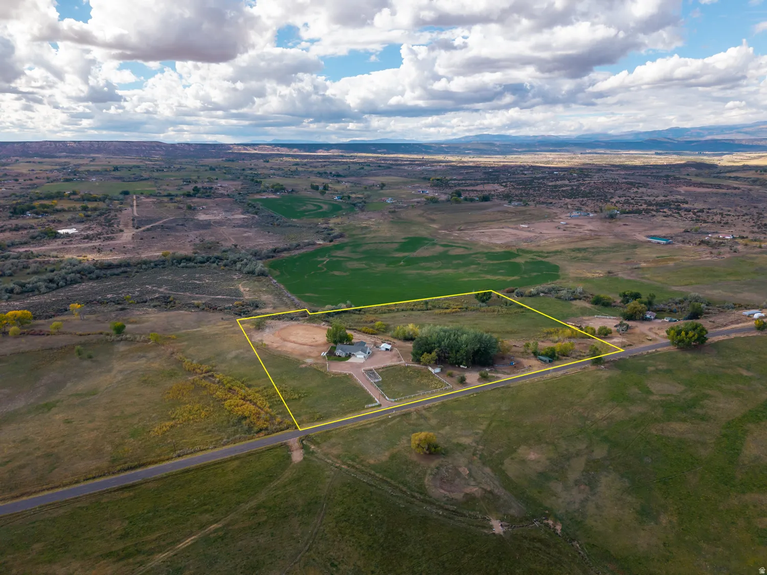 Aerial view of sparsely populated area featuring property boundaries highlighted and a mountainous background