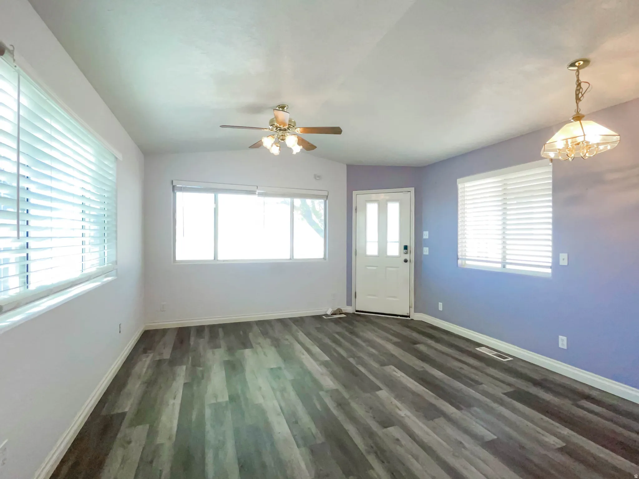 Foyer with lofted ceiling, ceiling fan, dark wood finished floors, and hanging lights