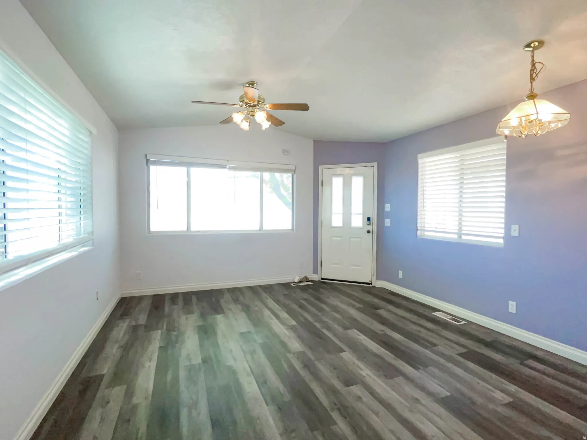 Foyer entrance featuring lofted ceiling, a ceiling fan, dark wood-type flooring, and hanging lights