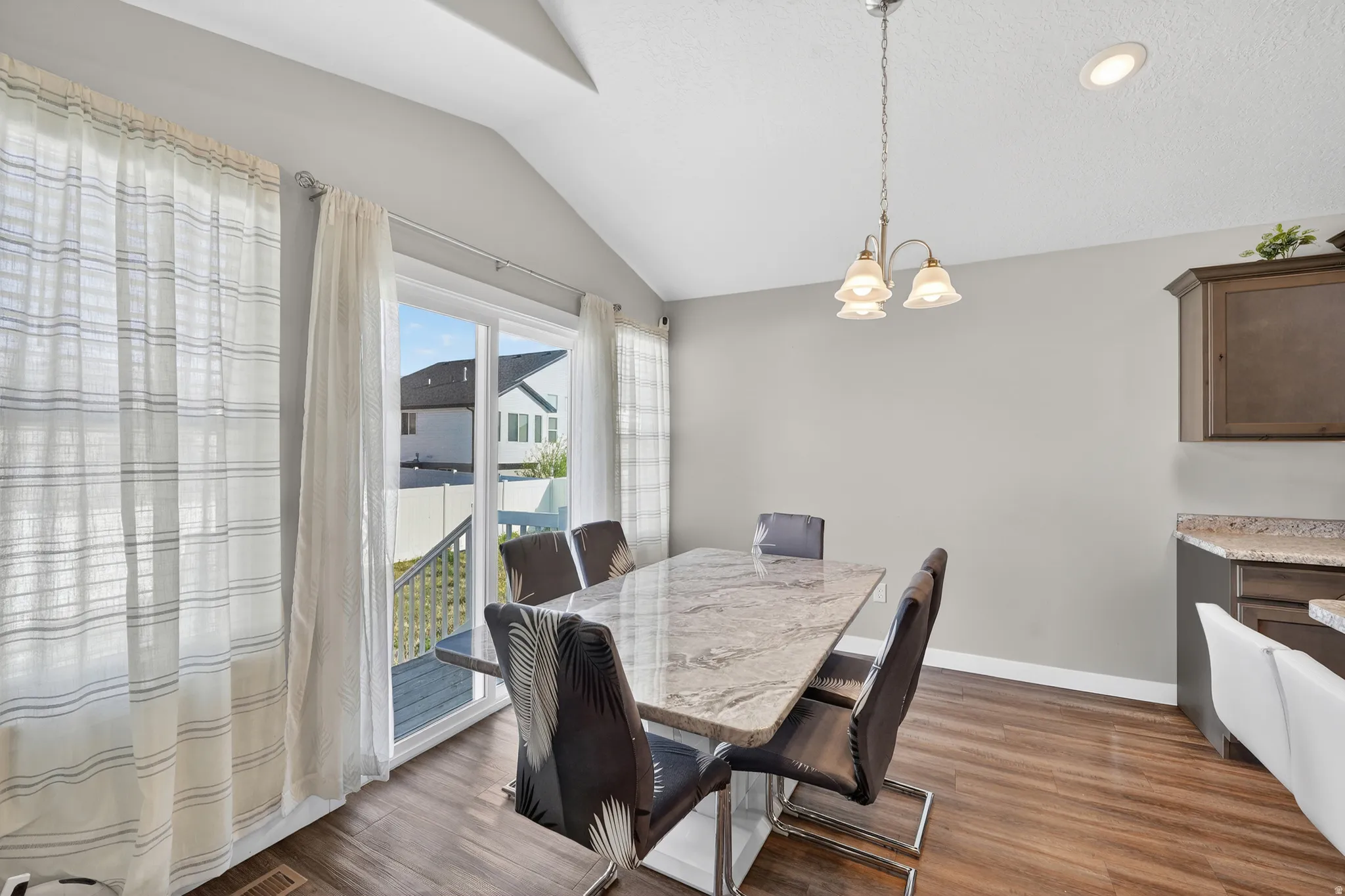 Dining space with dark wood finished floors and suspended lighting