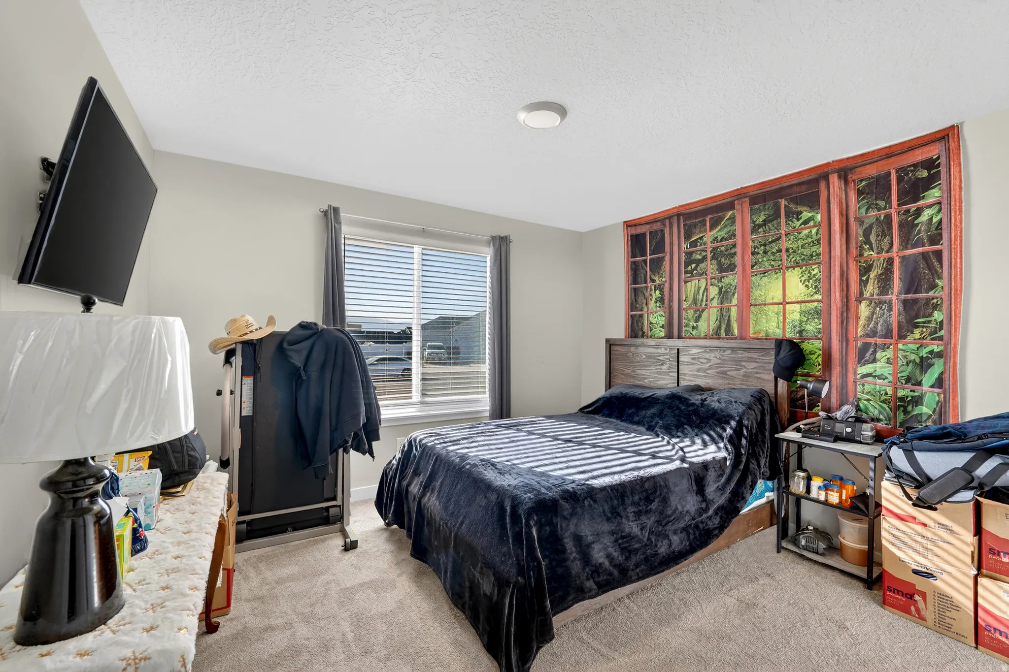Bedroom with light colored carpet and a textured ceiling