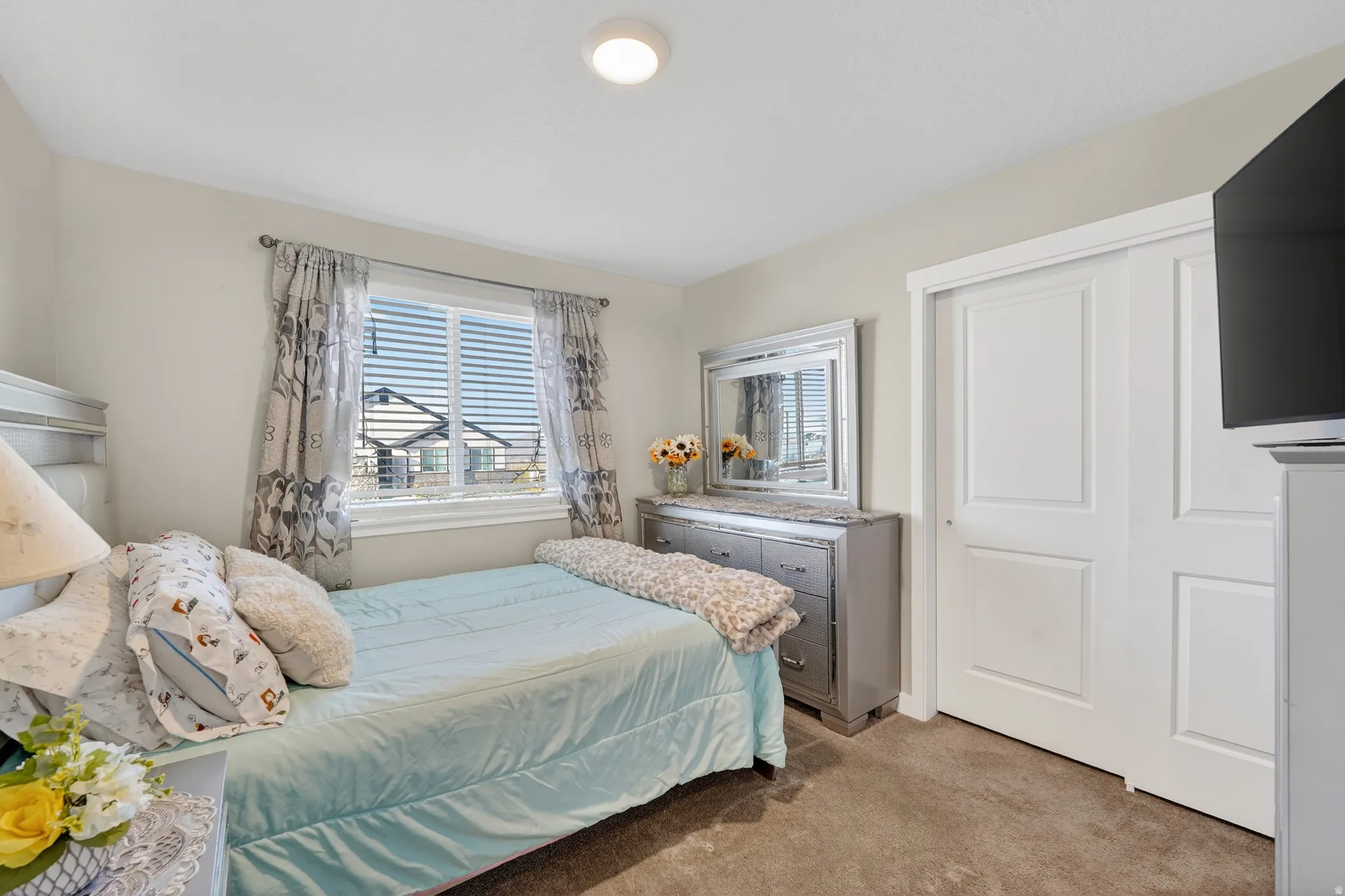 Bedroom with light colored carpet and a closet