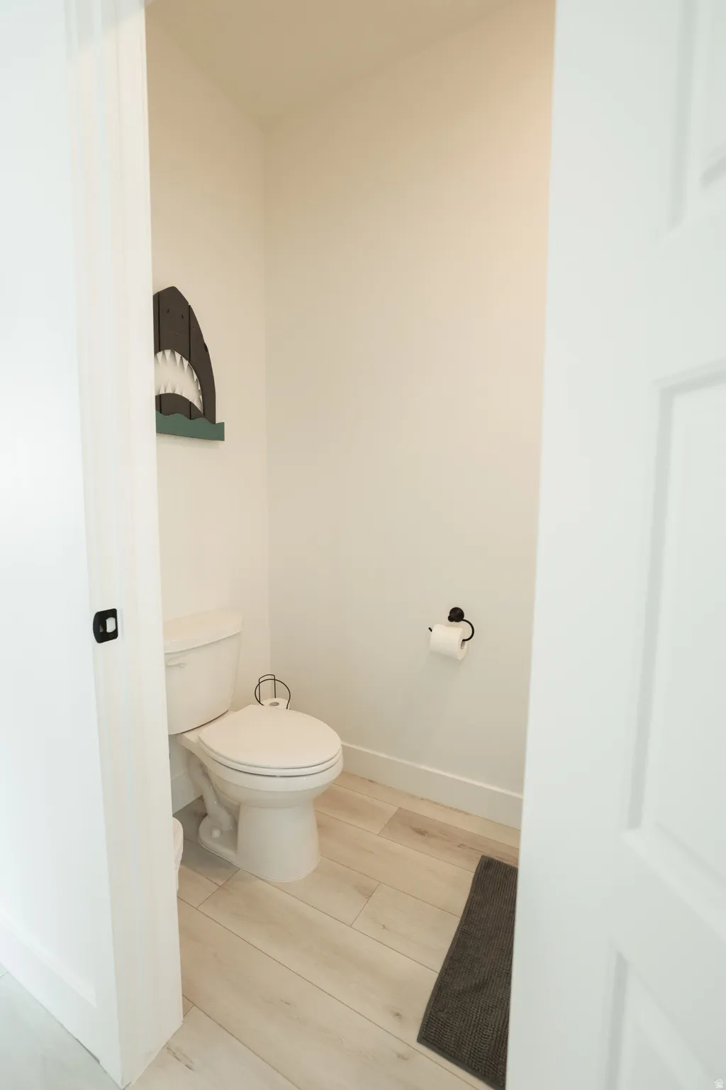 Bathroom featuring baseboards and light wood-style floors