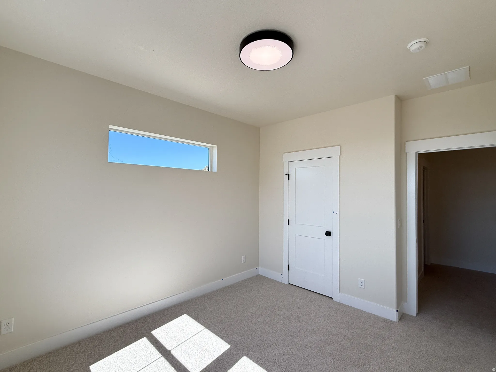 Unfurnished bedroom with light carpet