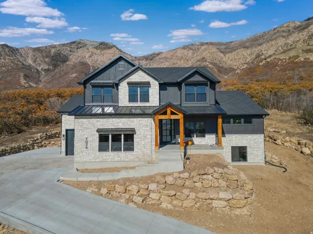 View of front of house featuring a standing seam roof, a porch, and a mountain view