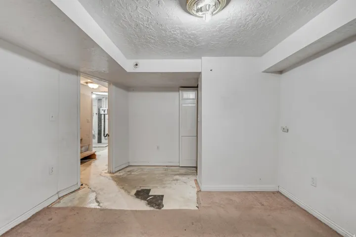 Spare room featuring a textured ceiling and unfinished concrete flooring