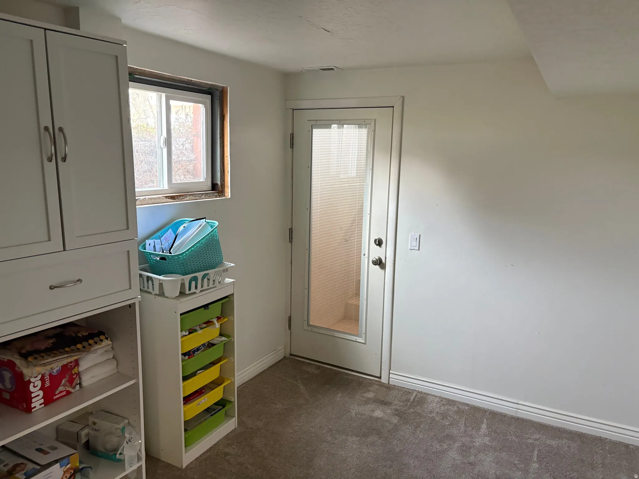 Doorway to outside with carpet and baseboards