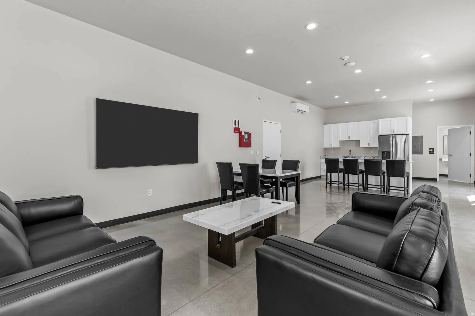 Living area with concrete flooring and recessed lighting