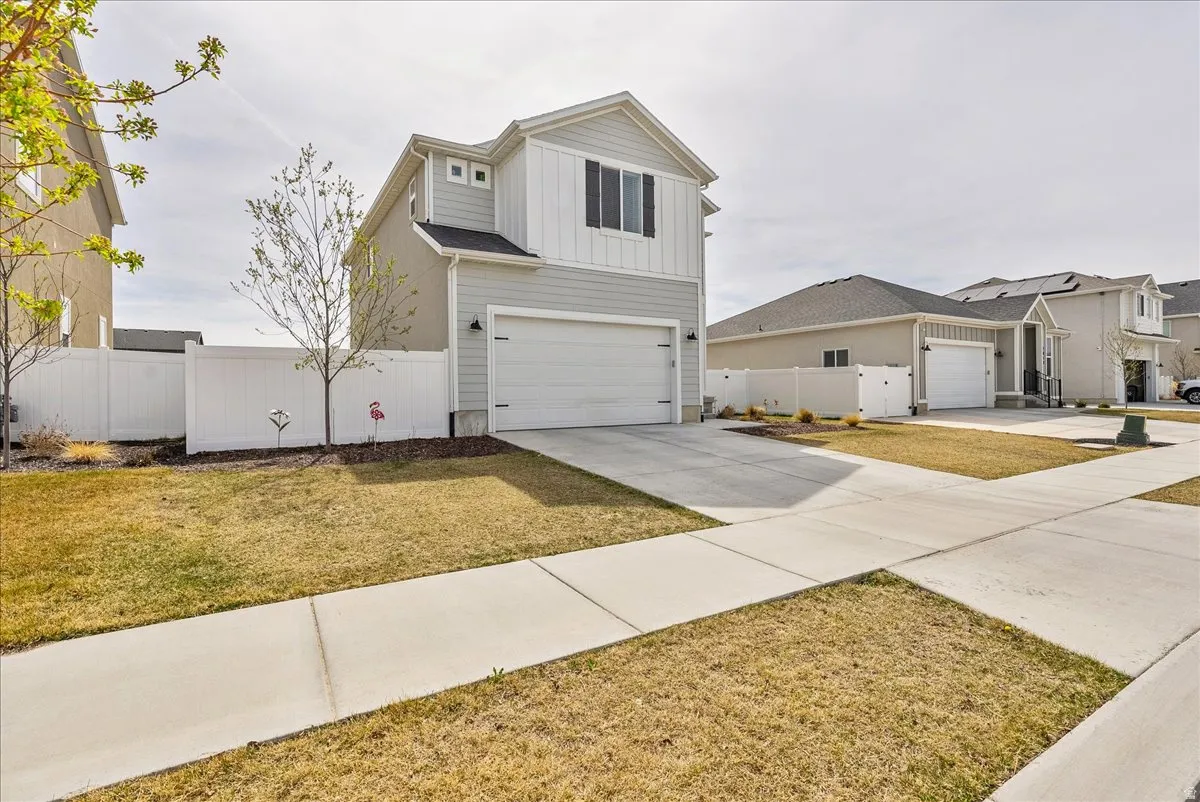View of front facade featuring driveway, an attached garage, and board and batten siding