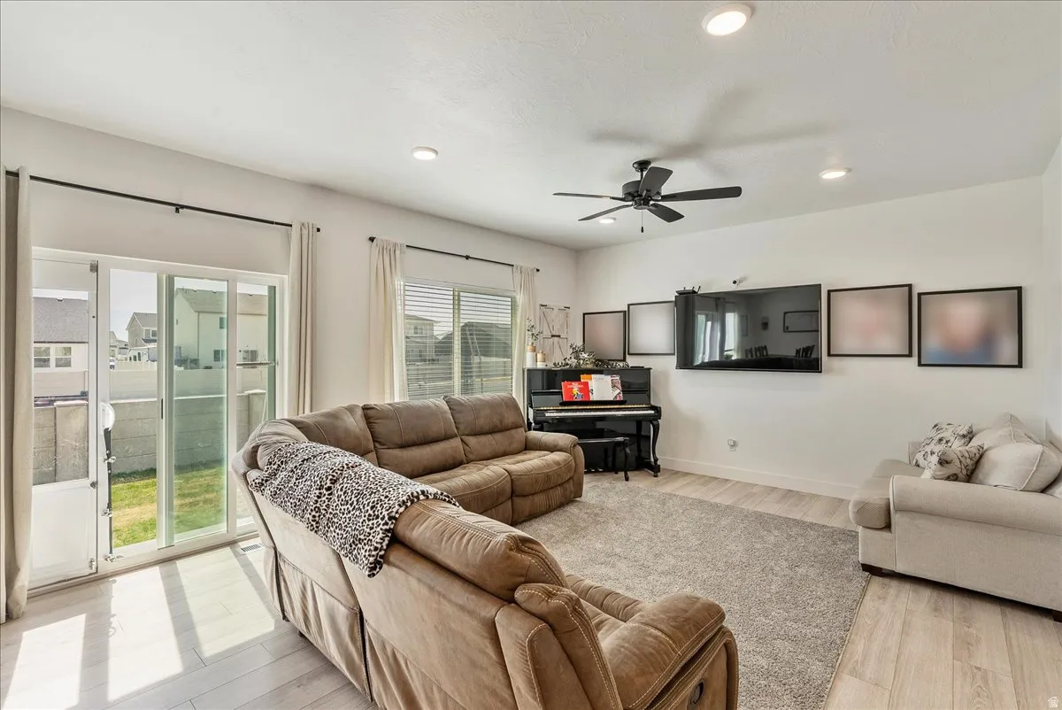 Living area featuring light wood finished floors, ceiling fan, and recessed lighting