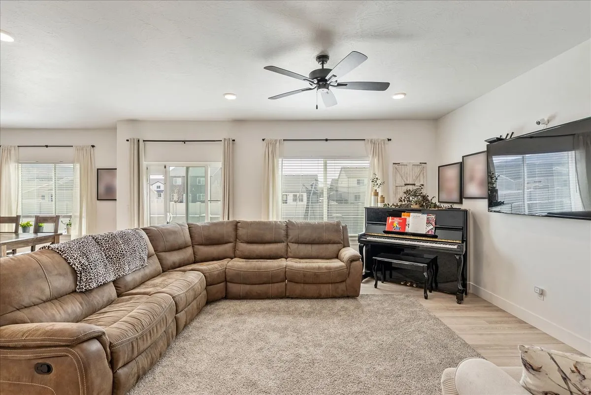 Living area featuring wood finished floors, a ceiling fan, healthy amount of natural light, and recessed lighting