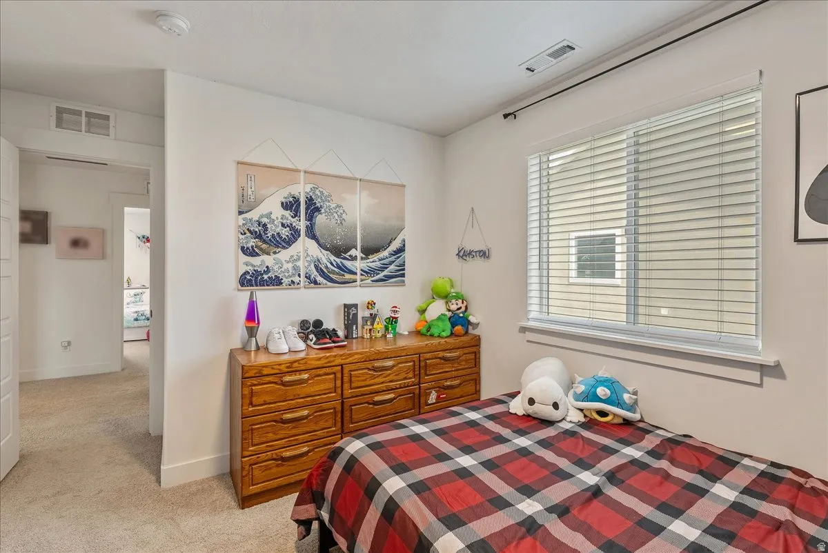 Bedroom with light carpet and baseboards
