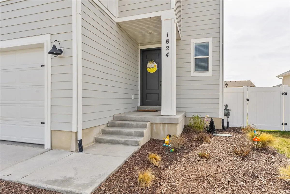 View of exterior entry with a gate and a garage