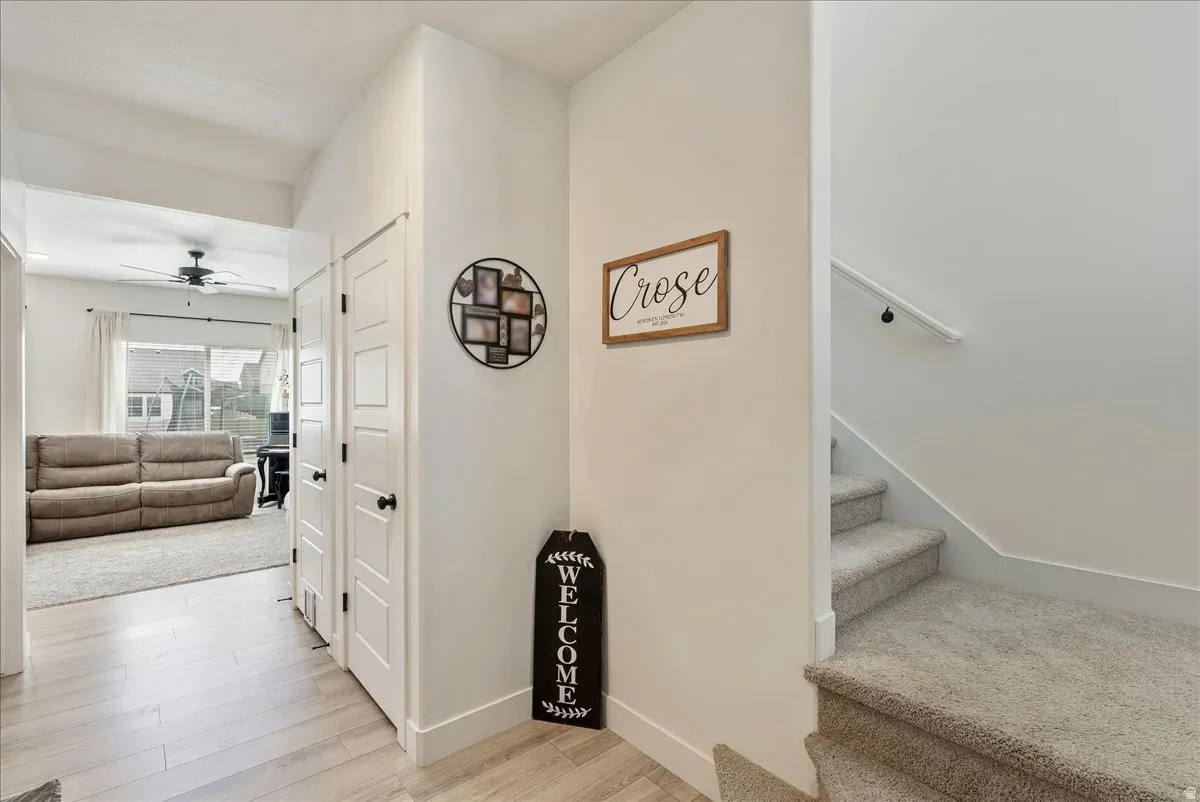 Staircase with wood finished floors and a ceiling fan