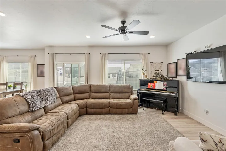 Living area featuring wood finished floors, a ceiling fan, healthy amount of natural light, and recessed lighting