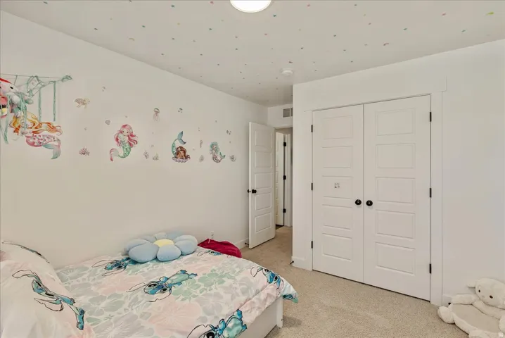 Bedroom featuring a closet and light colored carpet