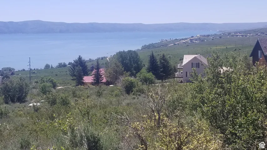 View of mountain backdrop featuring rural landscape and a nearby body of water