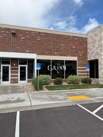 Property entrance featuring brick siding and uncovered parking
