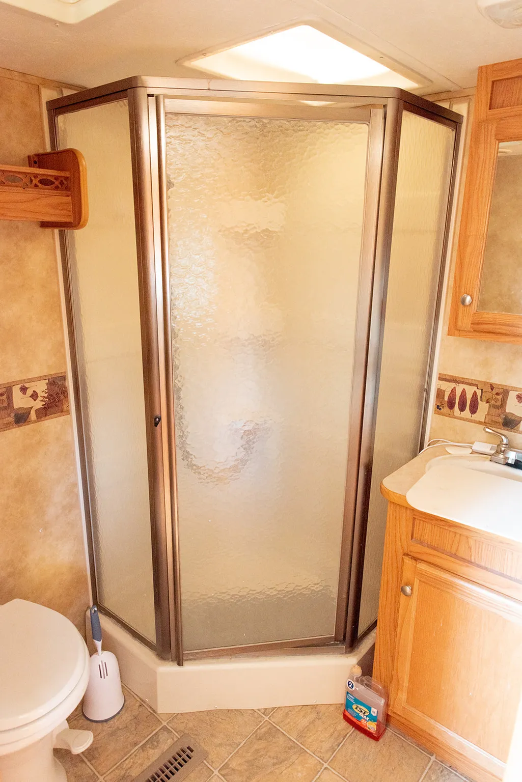 Full bathroom featuring a stall shower, vanity, and light tile patterned floors