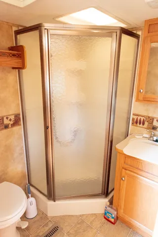 Full bathroom featuring a stall shower, vanity, and light tile patterned floors