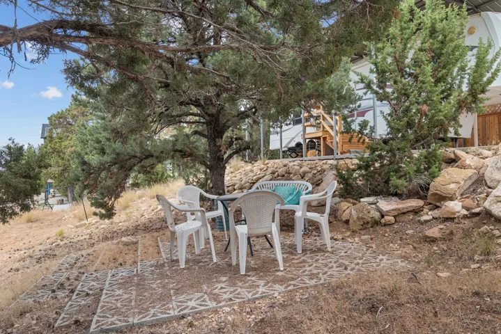 Outdoor patio space featuring a patterned paver base and natural landscaping