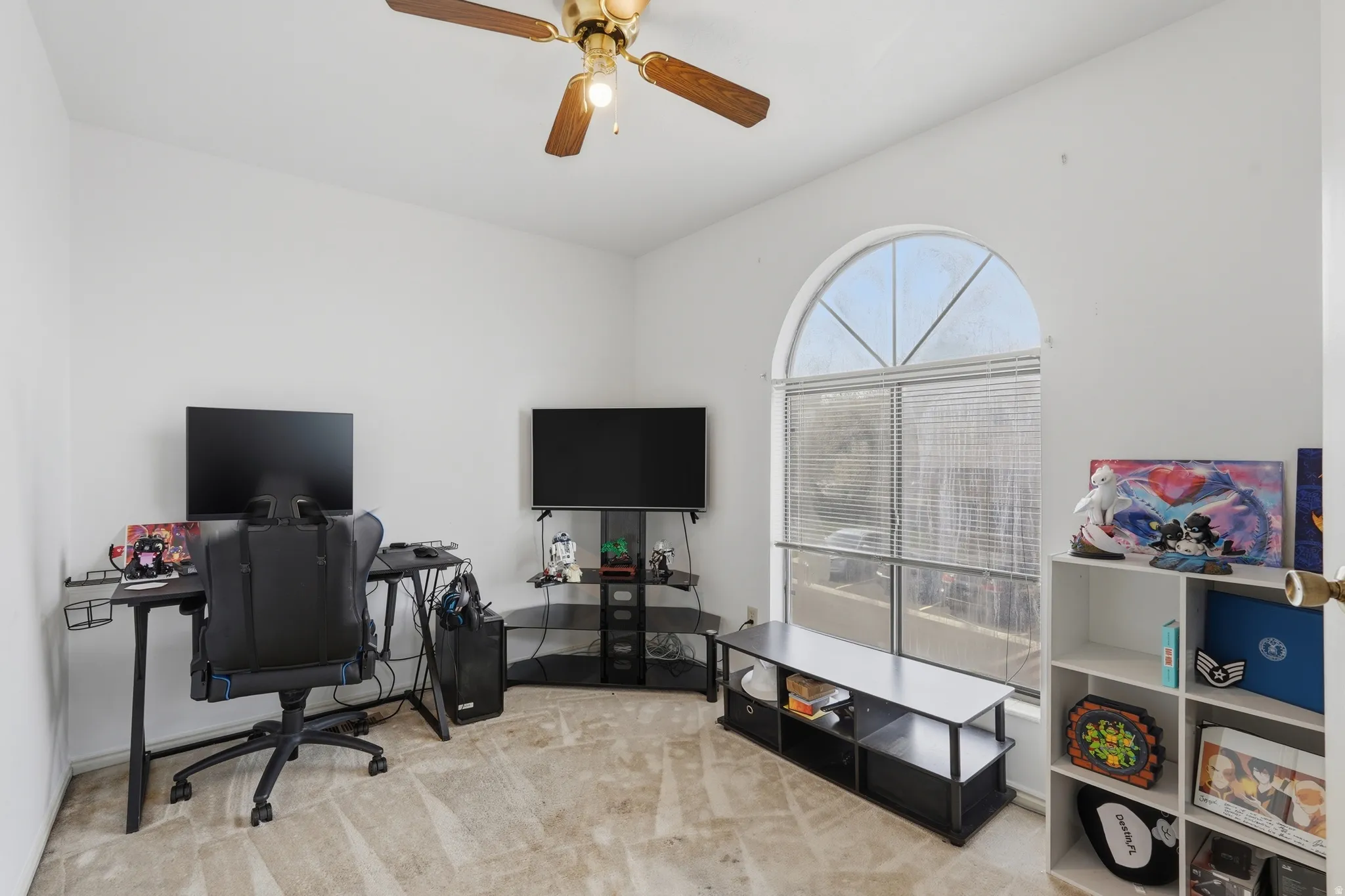 Home office with light carpet, a ceiling fan, and vaulted ceiling