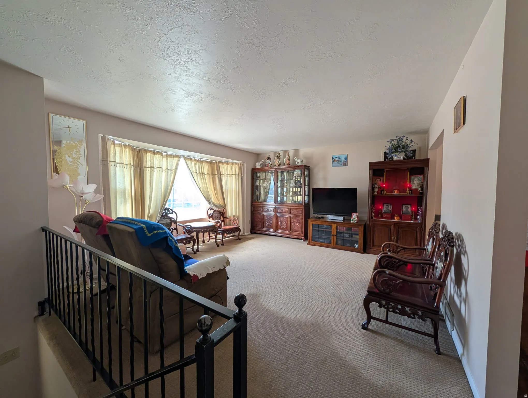 Carpeted living area featuring a textured ceiling