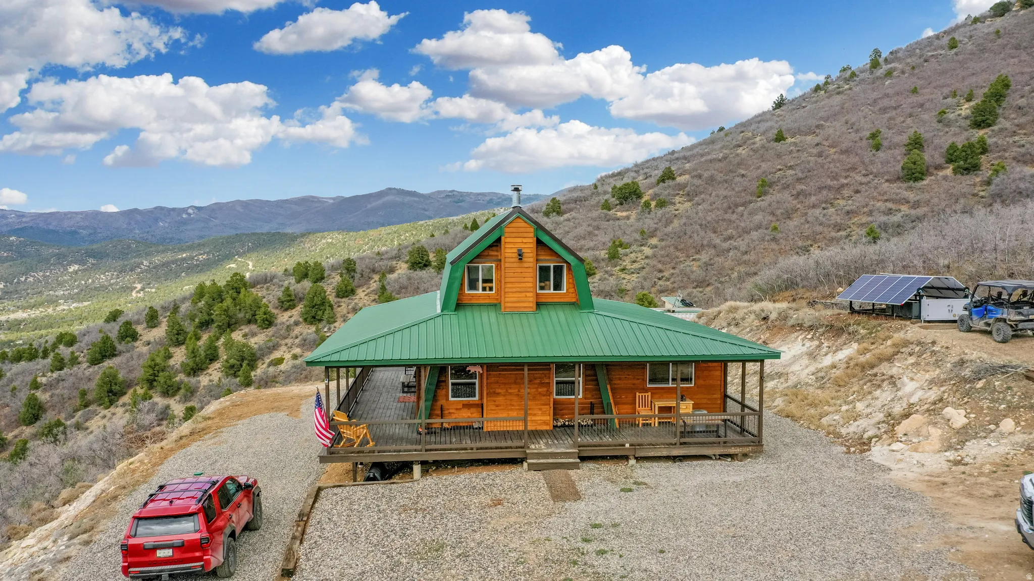 View of front of property with a porch, a mountain view, a metal roof, and solar panels