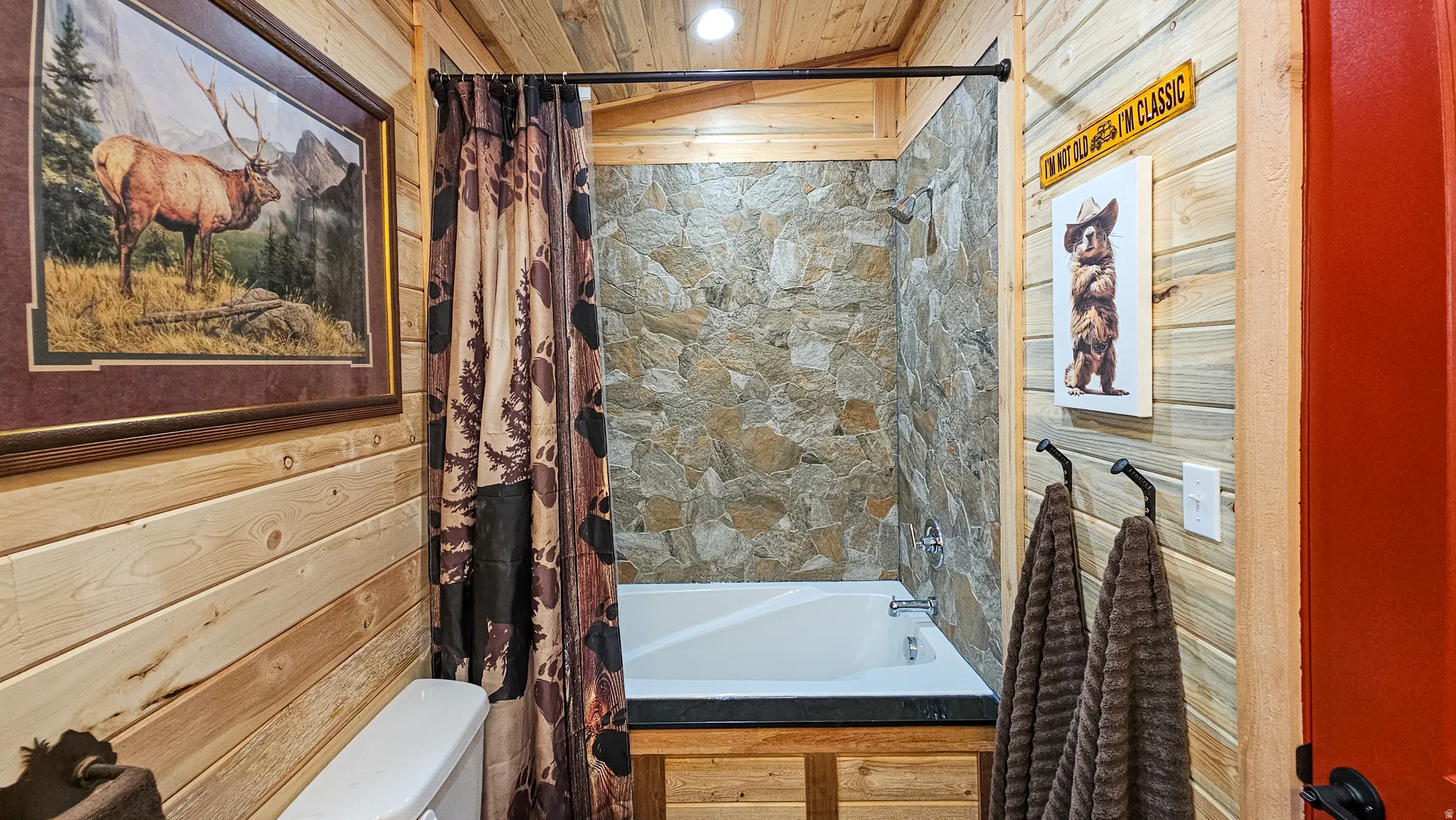 Bathroom featuring shower / bath combination with curtain and wood ceiling