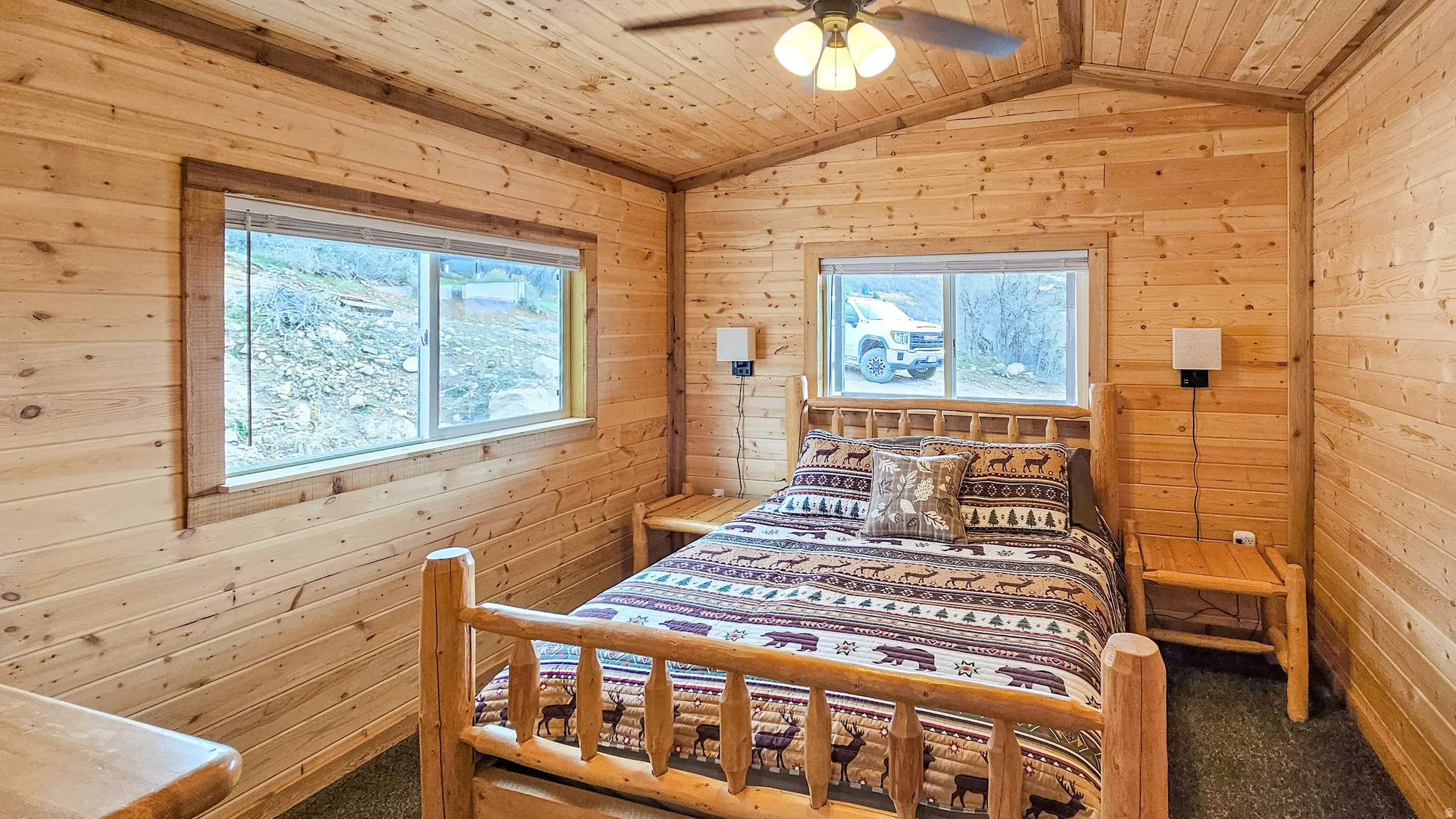 Carpeted bedroom with wooden walls, wooden ceiling, and ceiling fan