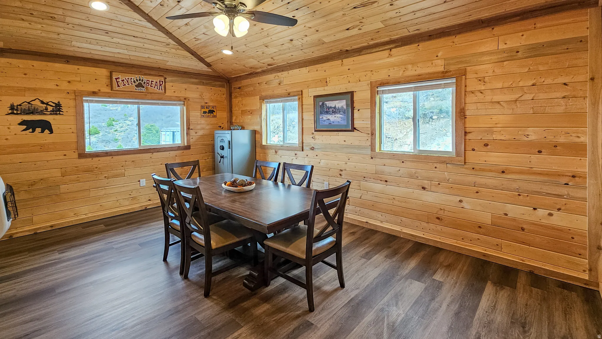 Dining area with wooden walls, ceiling fan, dark wood-type flooring, a vaulted wooden ceiling, and heating unit