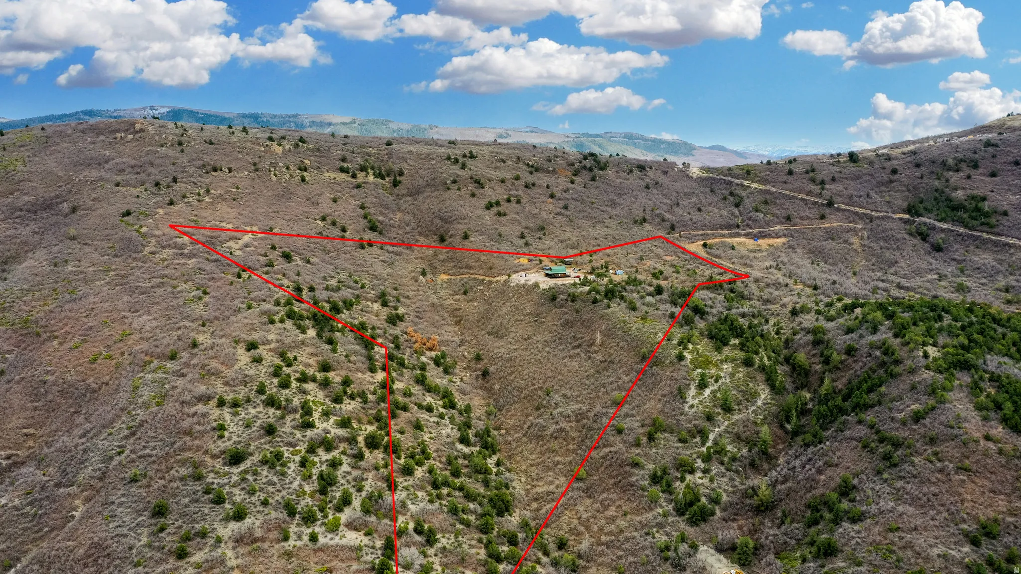Overview of rural landscape featuring property parcel outlined and a mountain backdrop