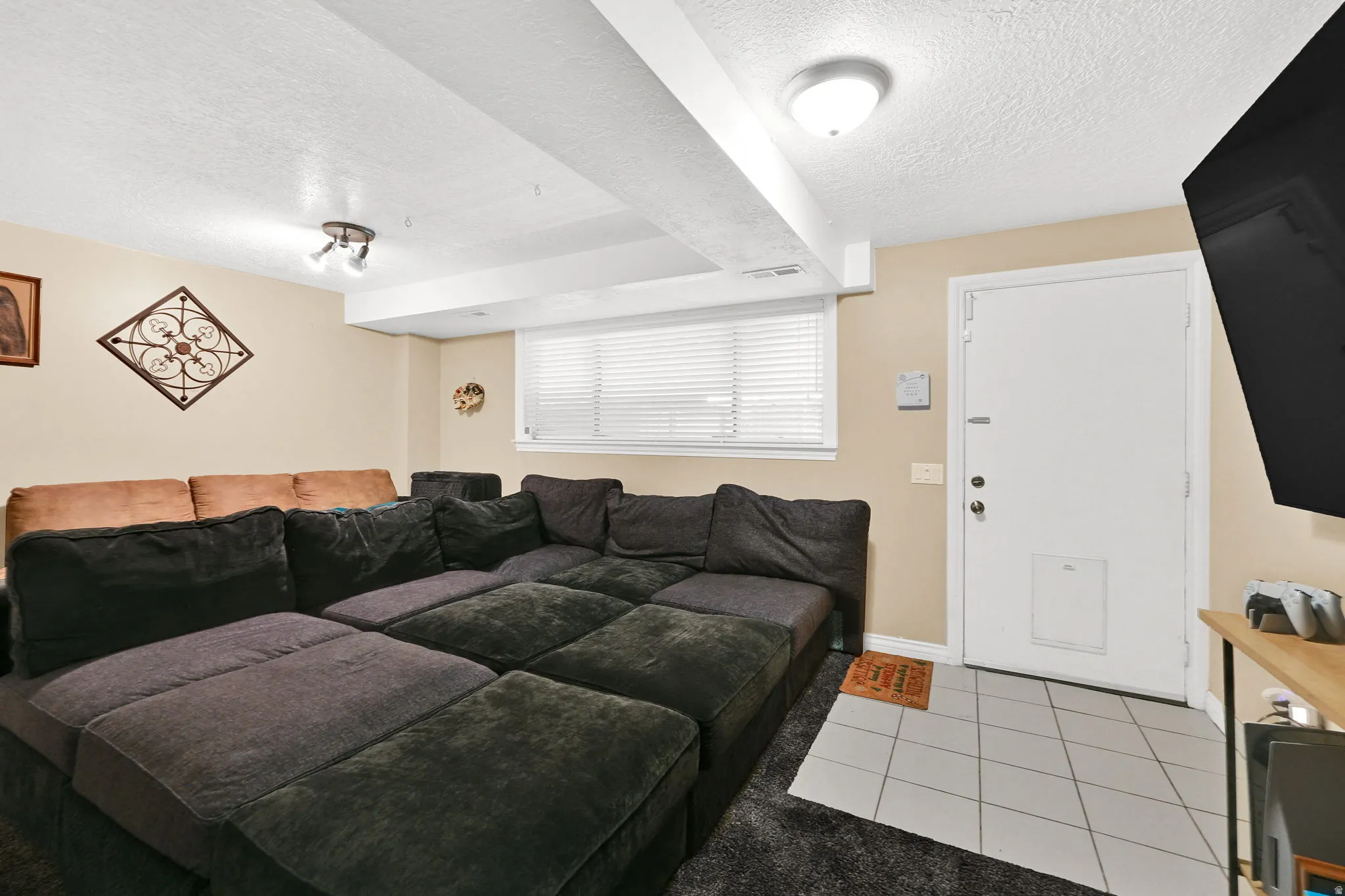 Living area with a textured ceiling and light tile patterned floors