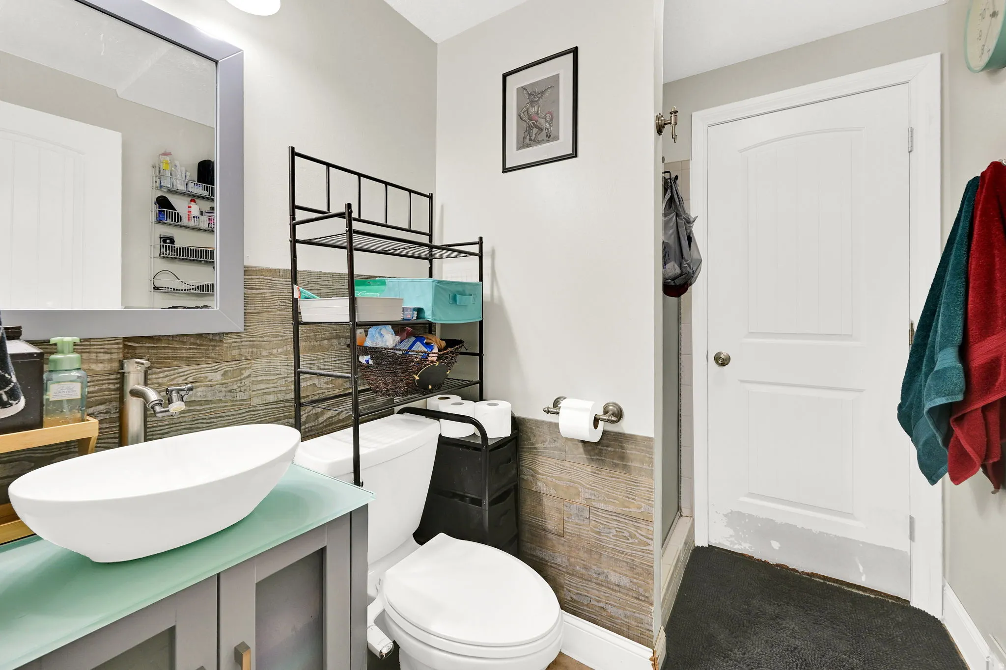 Bathroom featuring vanity, tile walls, and walk in shower