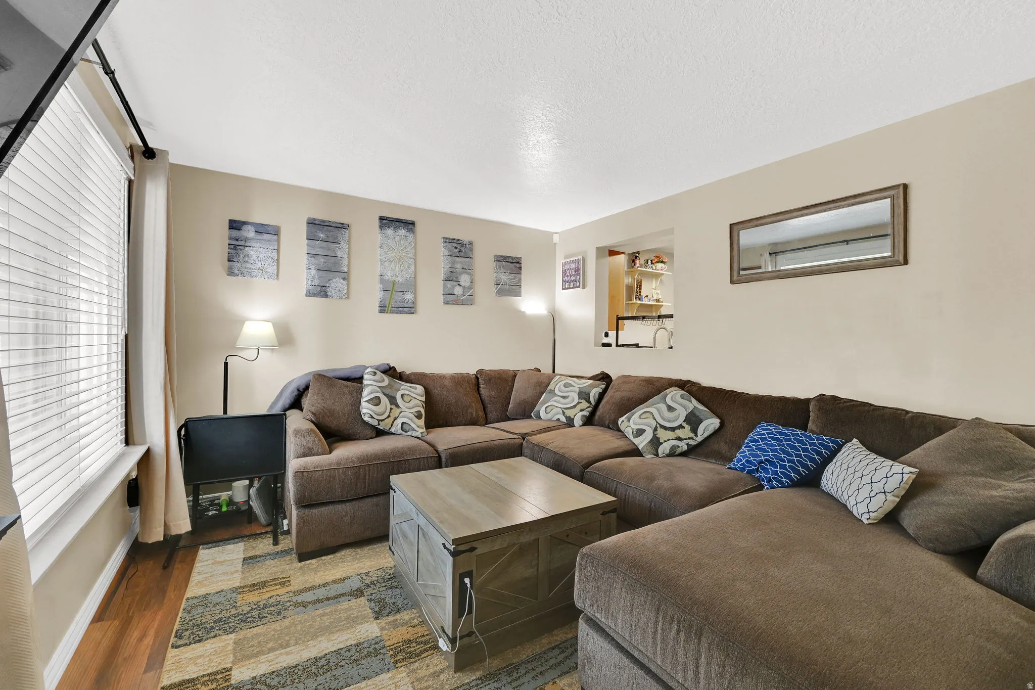 Living area featuring wood finished floors and a textured ceiling