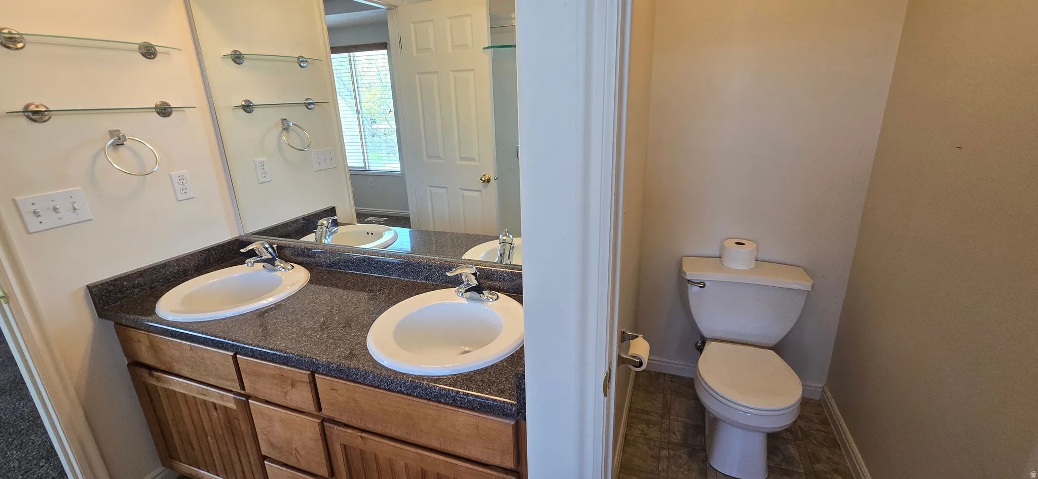 Full bathroom with double vanity and separate toilet