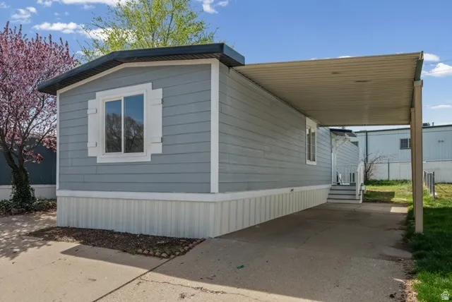 View of side of home featuring an attached carport