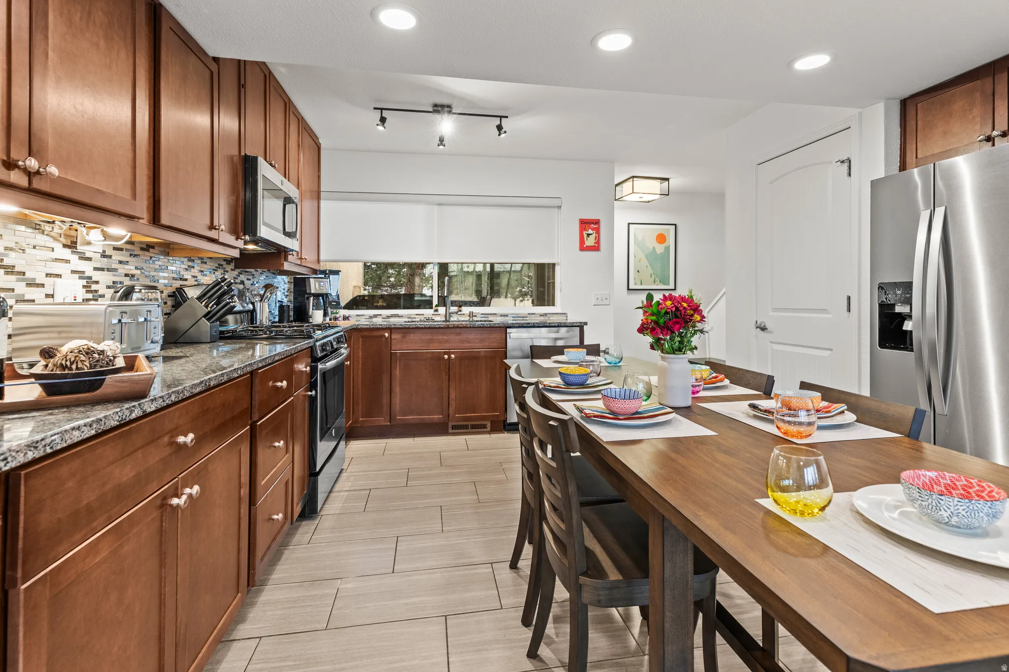 Kitchen featuring stainless steel appliances, dark stone countertops, tasteful backsplash, recessed lighting, and wood finish cabinetry