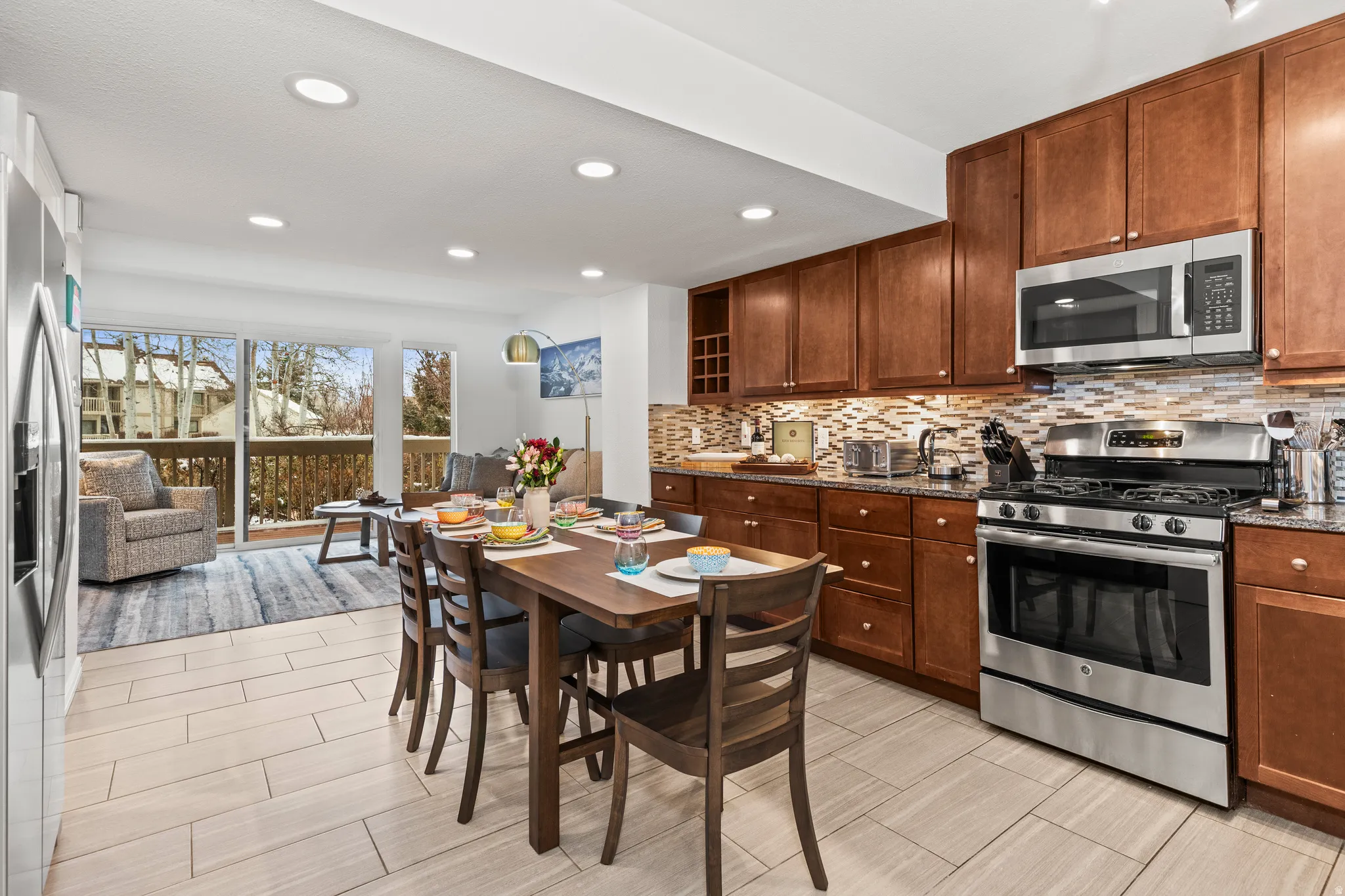 Kitchen featuring stainless steel appliances, dark stone countertops, recessed lighting, tasteful backsplash, and wood tiled floors