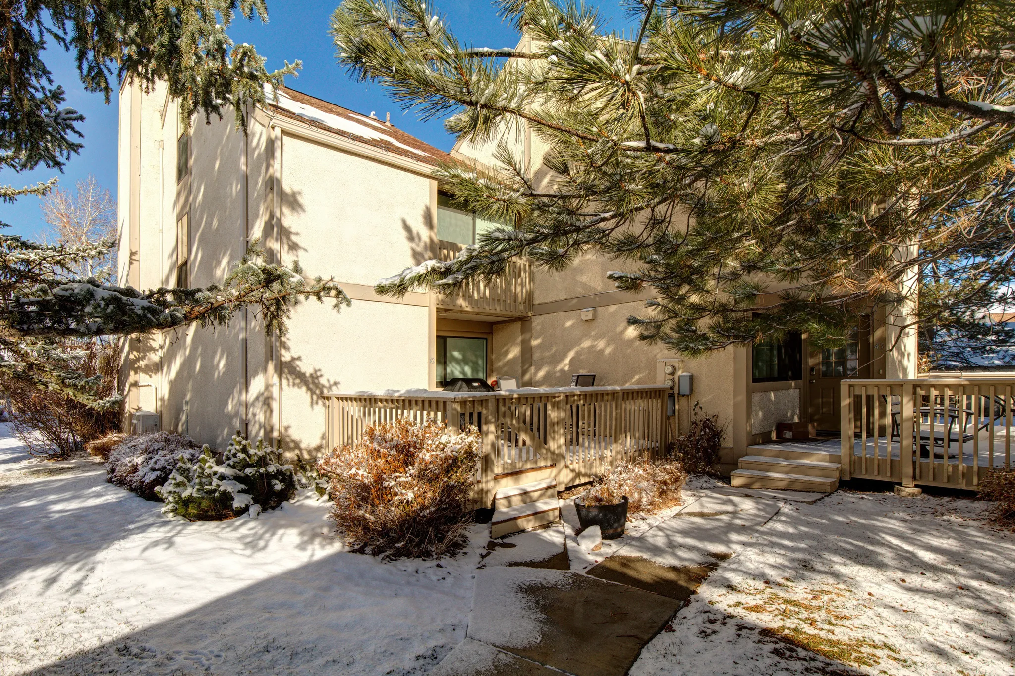 View of front of property with a wooden deck and stucco siding