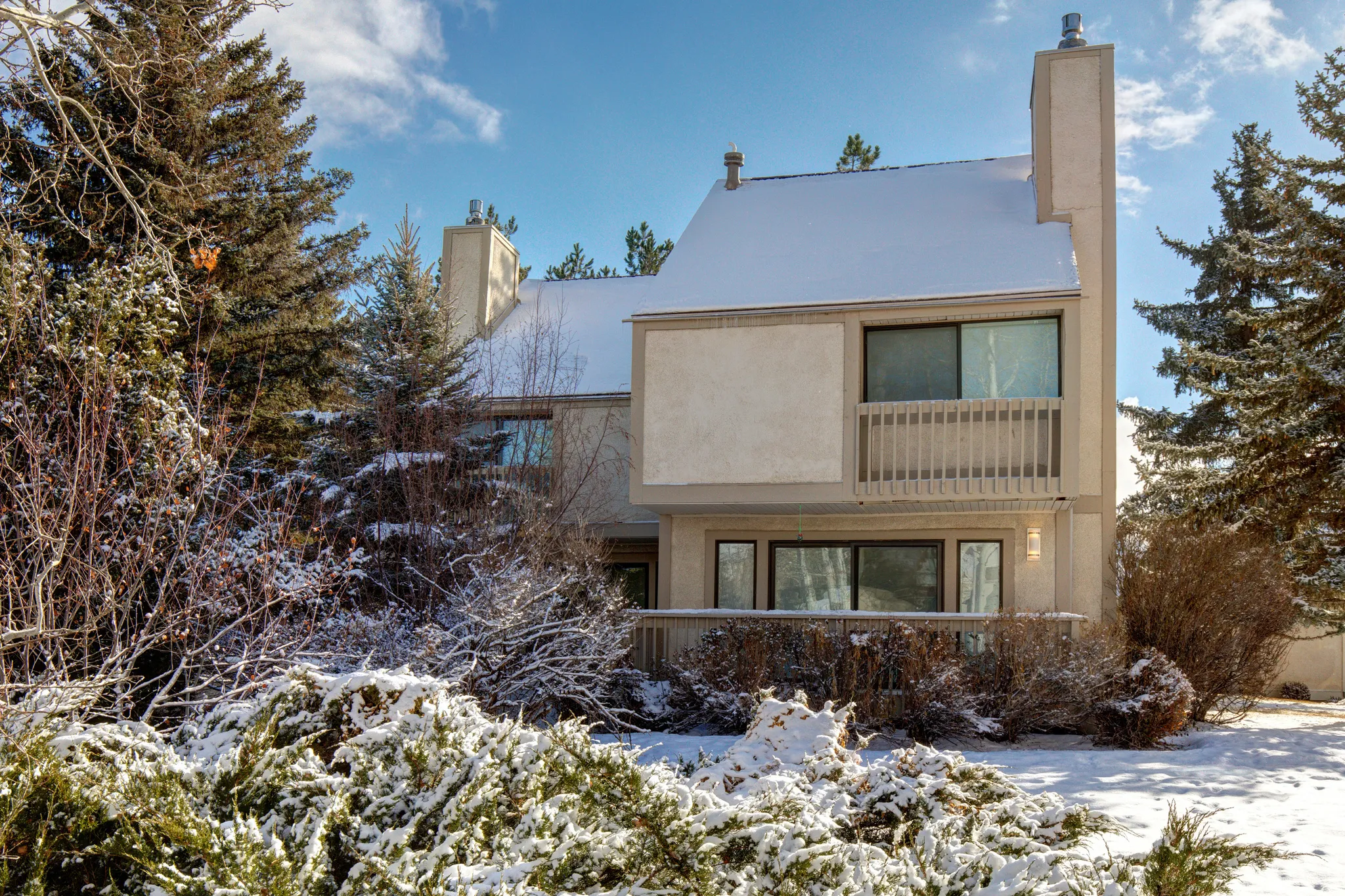 View of front of home with a chimney and stucco siding