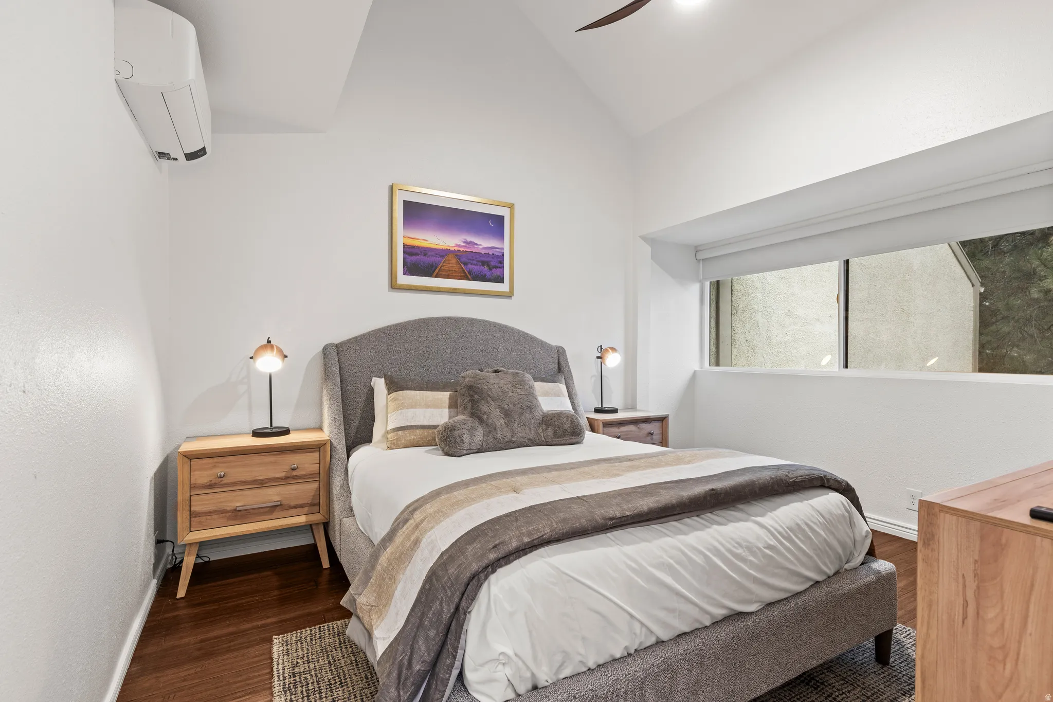 Bedroom with vaulted ceiling, wood finished floors, and a ceiling fan