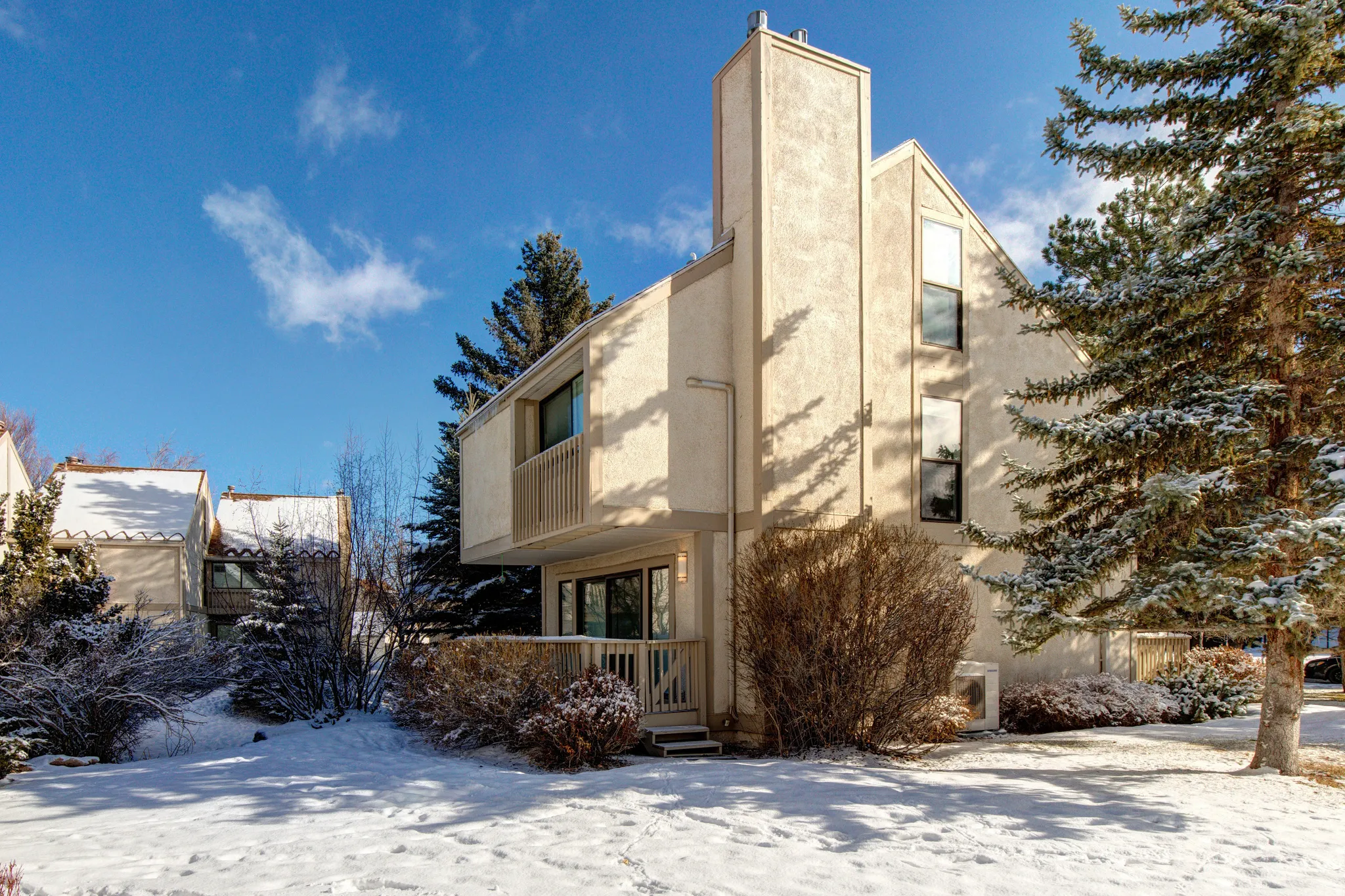 View of snowy exterior with stucco siding
