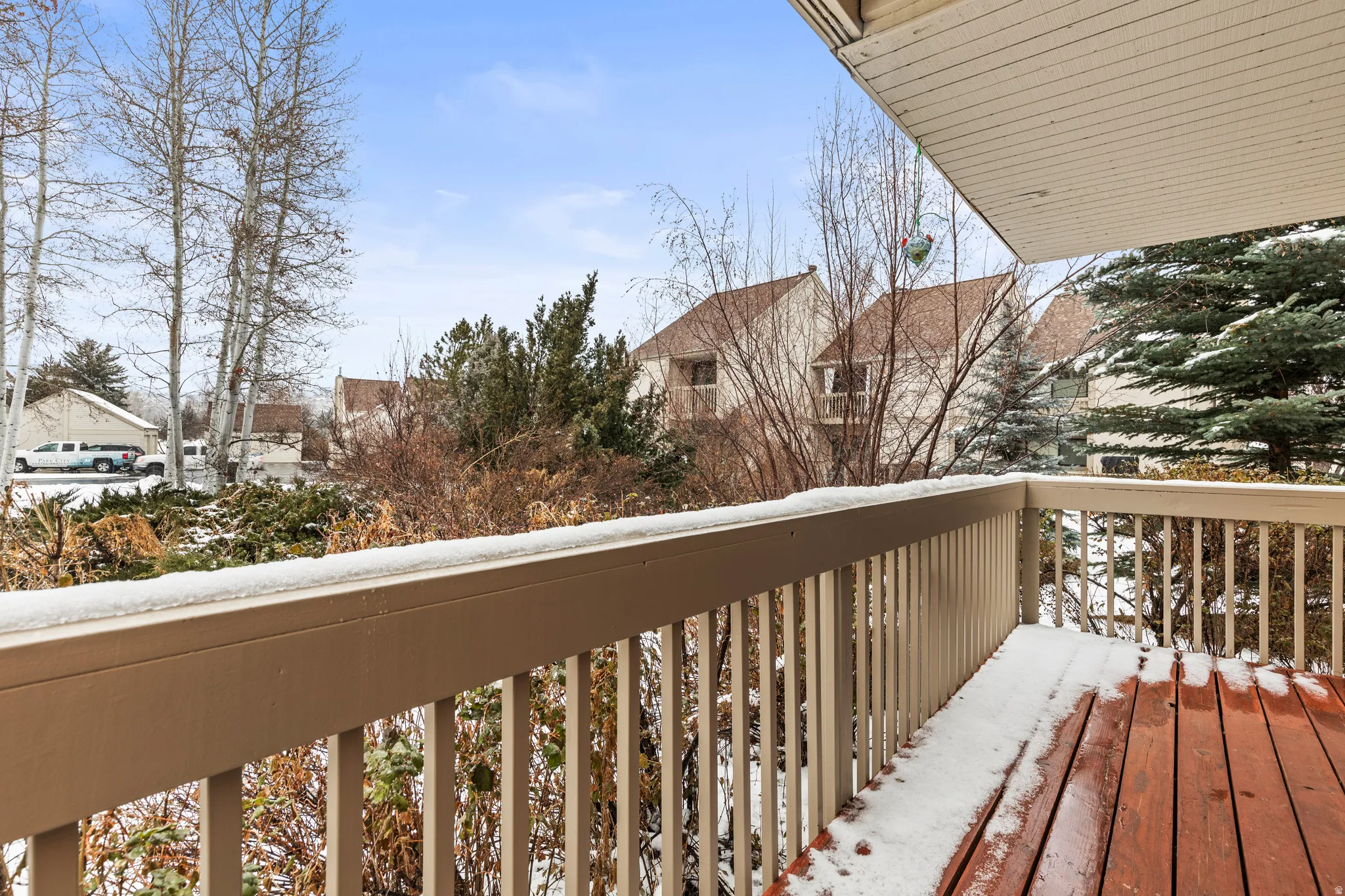 Snow covered back of property with a residential view